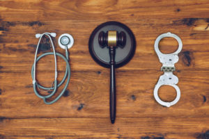 Handcuffs, stethoscope and judge gavel. Concept of healthcare and medicine, malpractice, legal system.